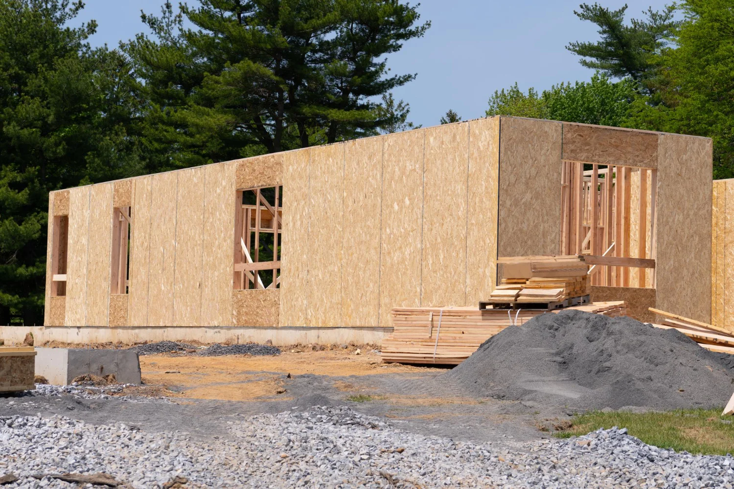 Rozostavaný drevodom so stenami z OSB dosiek a viditeľnou drevenou konštrukciou počas výstavby.