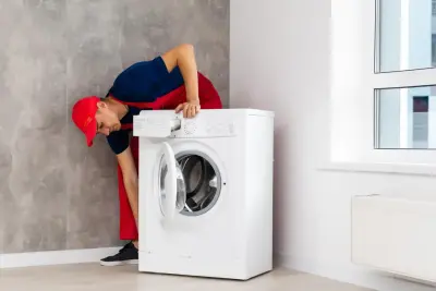 Servisný technik pri oprave práčky